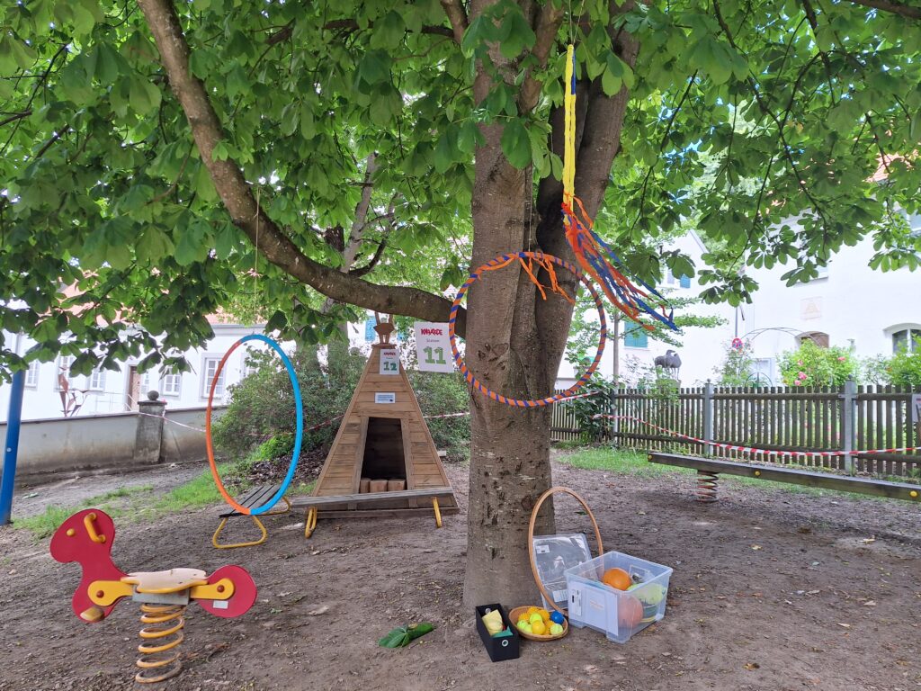 Bild mit Spielplatz, Baum und Gegenständen.