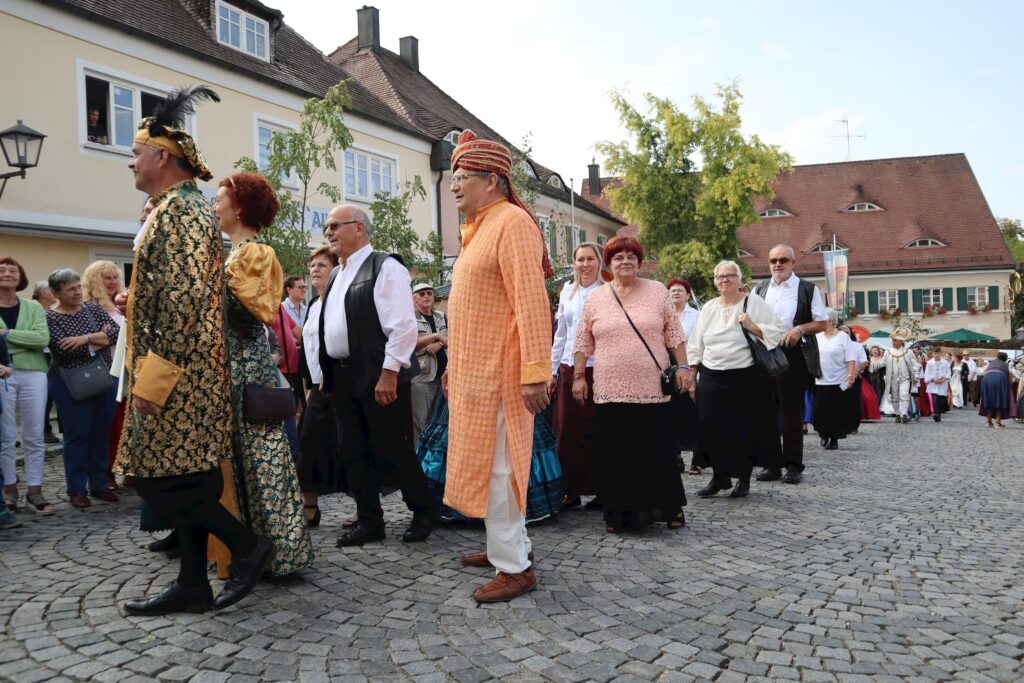 Ein Markt in Altomünster mit Menschen in traditioneller Kleidung auf dem gepflasterten Platz.