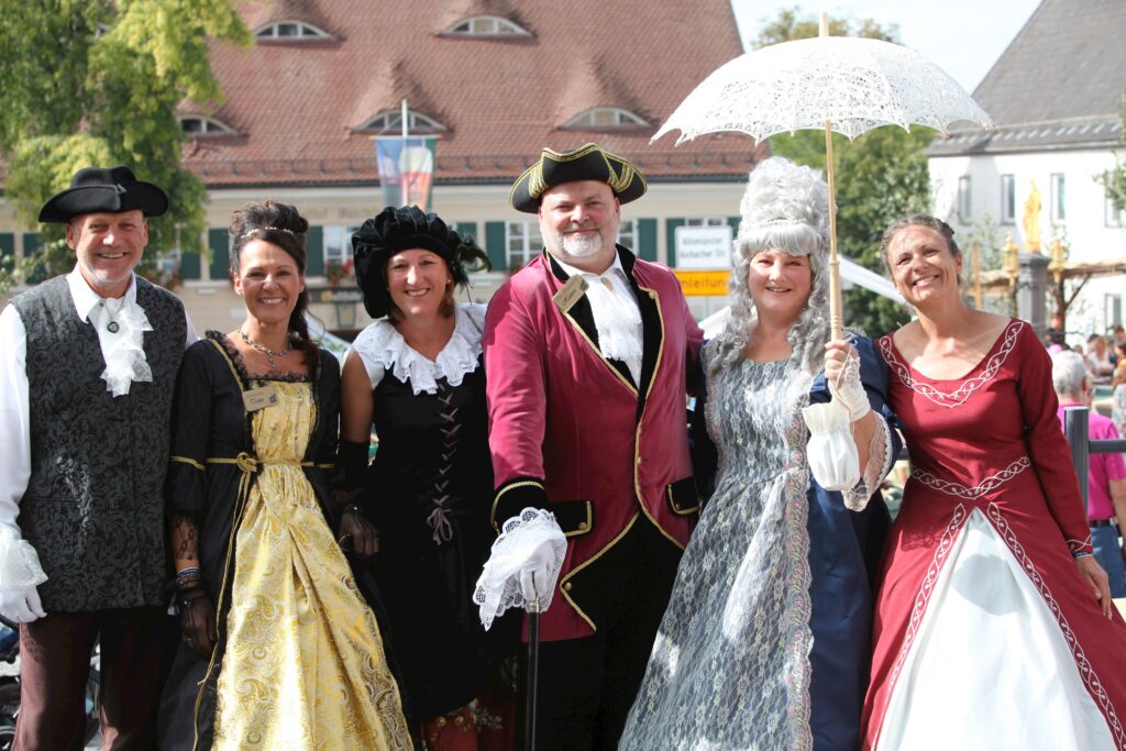 Fotografie von Marktstand in Altomünster, 6 Personen in historischen Kostümen.