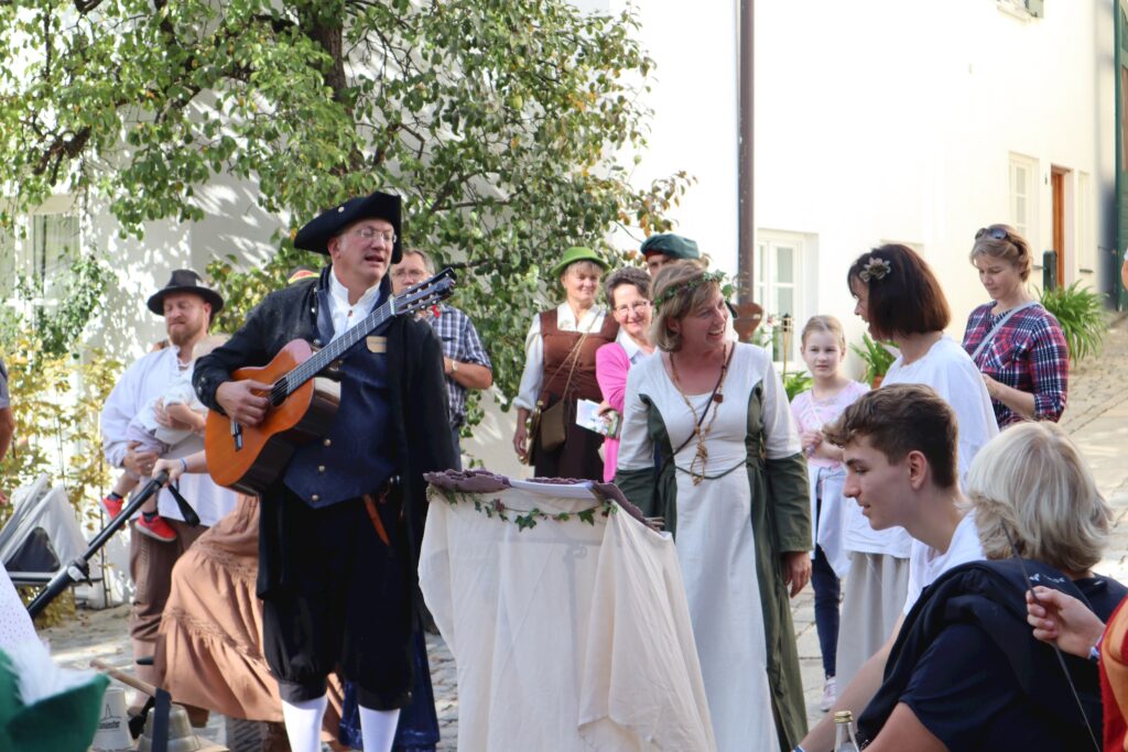 Markt Altomünster: Menschen in historischen Kostümen am Markt, mit Musik.