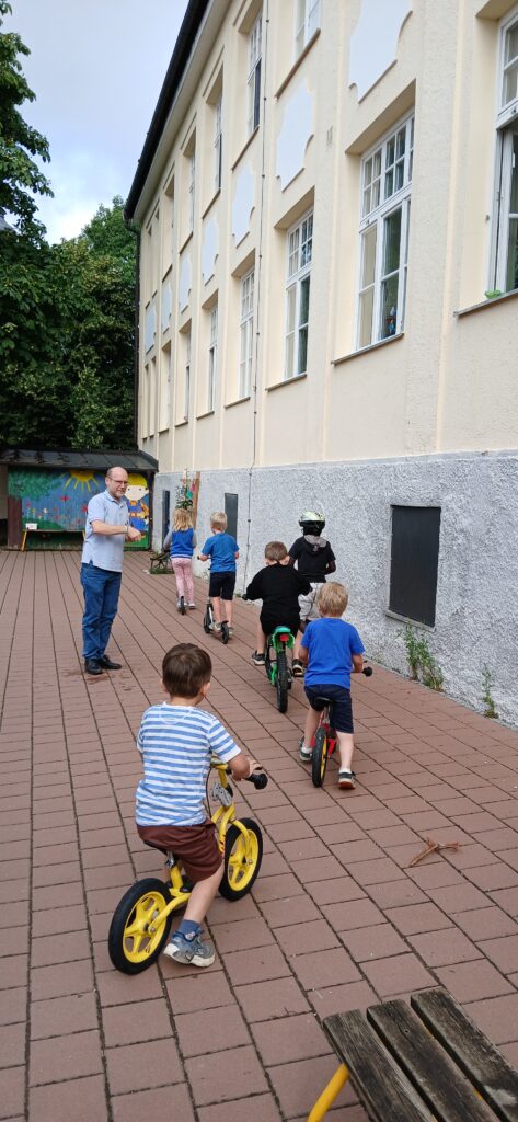 Kindern auf der Spielplatzscheibe mit Fahrrädern