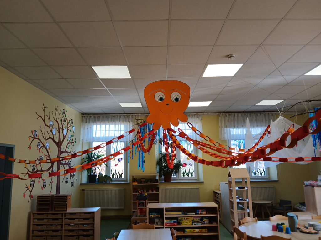 Ein Kinderzimmer mit einer großen, orangefarbenen, lächelnden Oktopusdekoration.