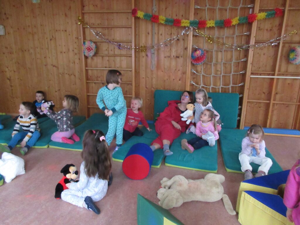 Ein Kinderzimmer mit Kindern und einer Erzieherin, Spielzeug und Spielgeräte.