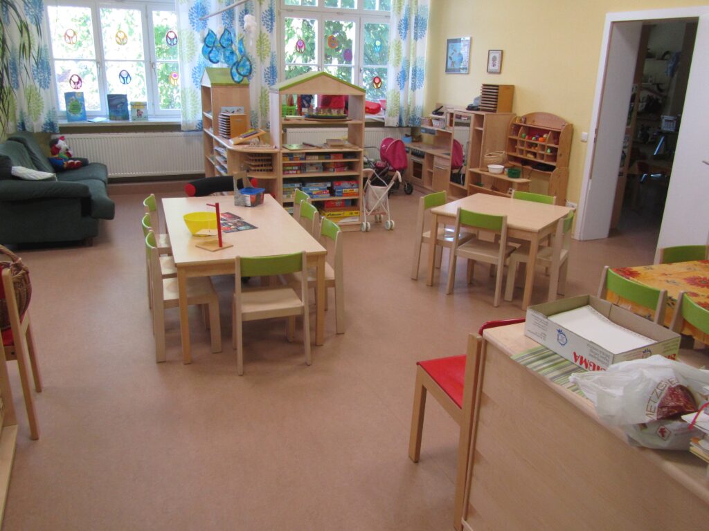 Kinderzimmer mit Tischen, Stühlen und Spielzeug im Markterium.