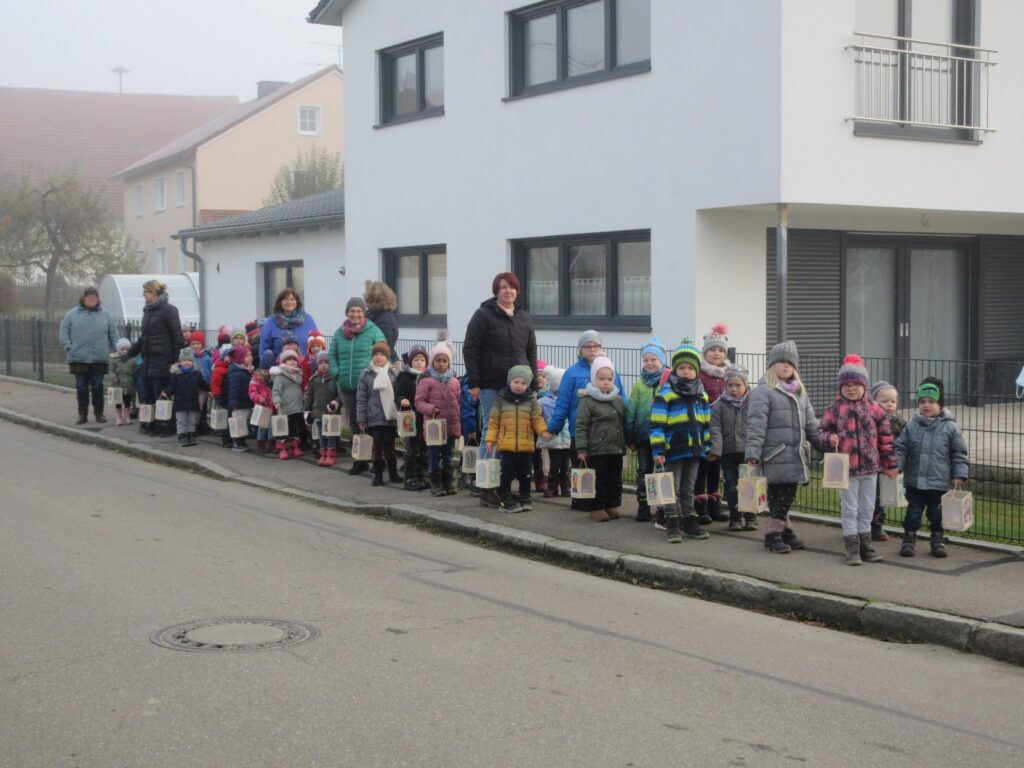 Gruppe von Kindern und Erwachsenen mit Laternen auf der Straße im Marktplatz Altomünster.