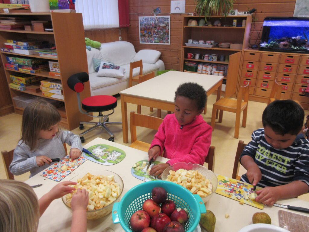 Ein Kinderzimmer mit Kindern, die Äpfel schäten.