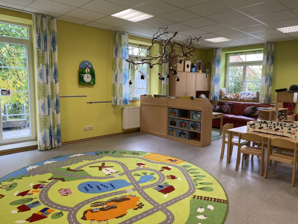 Ein Kinderzimmer mit Spielplatzmusterboden, gelben Wänden und Spielzeug.