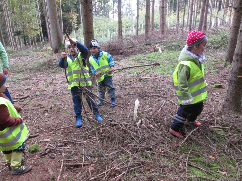 Kinder in Wald mit Rucksack und Schutzweste