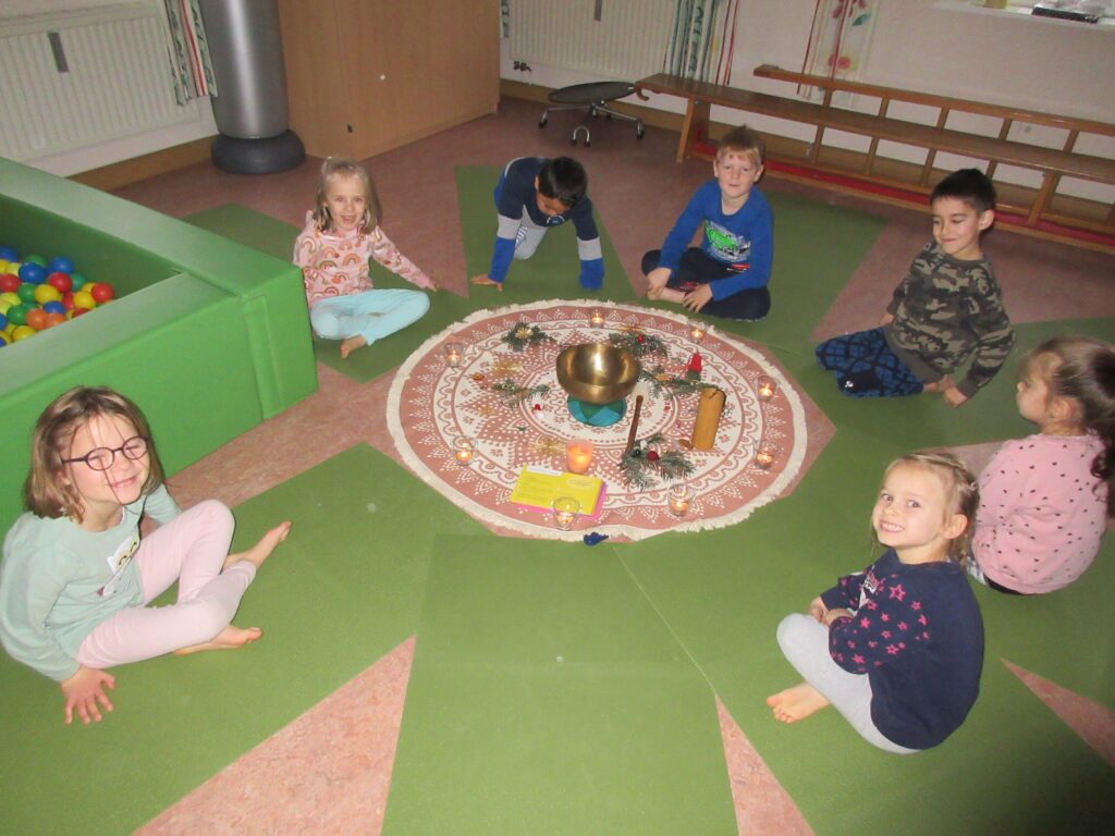 Kindern im Kreis um eine rituelle Zeremonie auf einem Mosaikboden.